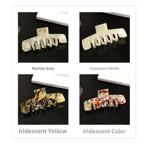 Detail view of large acetate hair claws in marble, pearl, amber, and mosaic textures
