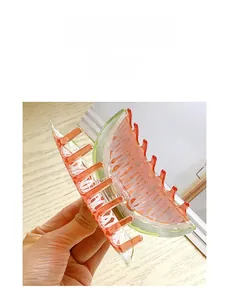 Detail of watermelon acrylic hair claw clip showing translucent texture and metal spring