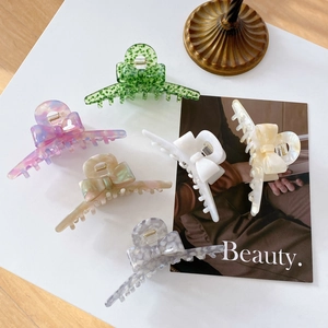Set of six elegant acetate bow hair claws in marble and solid finishes on white background