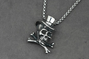 Macro shot of gothic skull with top hat pendant and durable silver box chain