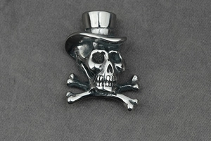 Detail of vintage silver titanium steel skull pendant with top hat and crossbones design
