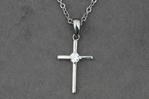 Détail d'un pendentif croix en argent serti d'un zircon brillant au centre