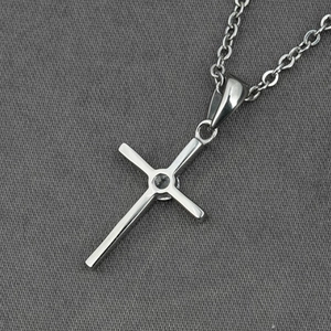 Collier croix minimaliste en argent avec pierre de zircon sur fond en tissu texturé