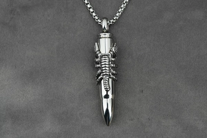 Detail view of titanium steel bullet pendant with engraved scorpion on matte background