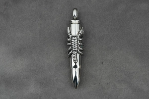 Detailed view of silver bullet pendant with a detailed scorpion relief in titanium steel