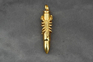 Detailed close-up of golden bullet pendant featuring a unique 3D scorpion relief sculpture