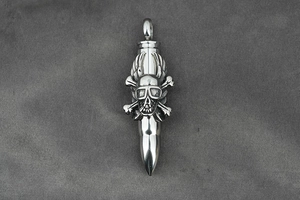 Macro detail of gothic punk silver bullet pendant with skull wing and goggle carvings