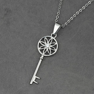 Collier avec pendentif clé en acier titane, fleur évidée et incrustation de zircon