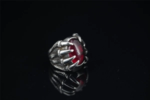 Macro shot of gothic dragon claw ring featuring a large oval red ruby gemstone