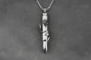 Detail of bullet pendant with embossed rose texture and square chain in retro silver finish