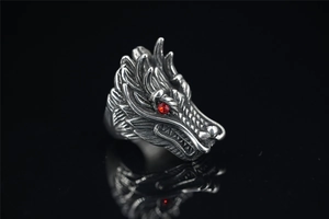 Macro detail of silver punk wolf head ring with red gem eyes and engraved scales
