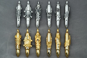 Detail of 12 bullet pendants in gold and silver with eagle, skull, and rose motifs