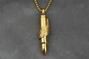Macro detail of golden bullet pendant featuring intricate feather relief and box chain