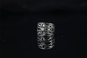 Détail macro d'une bague araignée gothique avec pierre en zircon sur fond noir brillant
