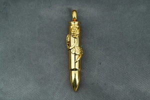 Detail of gold bullet pendant featuring intricate rose and leaf embossed engraving