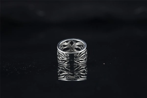 Détail d'une bague punk évidée en acier titane avec gravures vintage et reflets polis