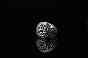 Macro detail of vintage hexagram star signet ring with intricate engraved hollow patterns