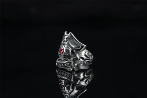 Detailed close-up of a vintage pirate skull ring with a striking red gem in the eye socket