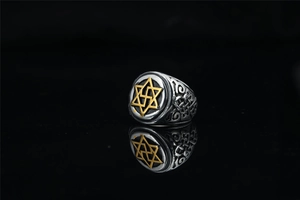 Detail of vintage steel ring featuring golden hexagram and Celtic knot side carvings