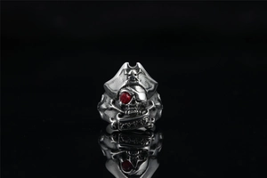 Macro shot of pirate skull ring with red gemstone eye and detailed metallic carving