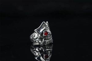 Macro detail of vintage pirate skull ring with red zircon eye and antique steel texture