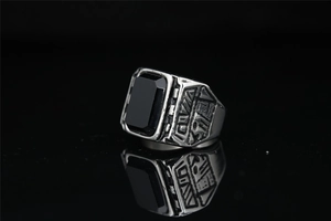 Macro shot of silver titanium steel ring featuring a large rectangular black gemstone inlay