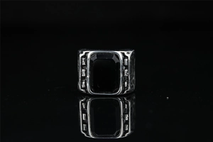 Macro detail of vintage men's titanium ring with black rectangular gemstone and carvings