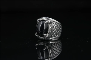 Detail of vintage steel dragon claw ring featuring a large black onyx stone and scales