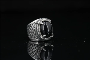 Macro detail of dragon claw ring with black onyx stone and engraved scale textures