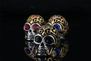 Macro shot of punk skull rings with colorful crystal eyes and gothic relief detailing