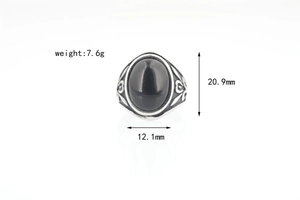 Macro detail of vintage silver ring with black oval stone and intricate floral carving