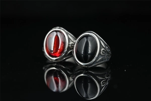 Macro shot of vintage Mayan style steel rings with red and black gemstone inlay