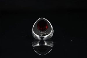 Detail of vintage Mayan style steel ring featuring an oval red stone and intricate carvings