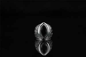 Detail of vintage punk ring with black marquise stone and mechanical gear textures
