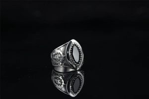 Detailed view of punk rocker skull ring with black marquise gem and embossed silver wings