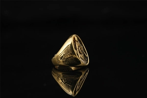 Macro shot of gold Masonic signet ring with compass square symbol and letter G detailing