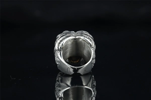 Macro shot of punk biker wing ring with vintage silver floral relief and brushed interior
