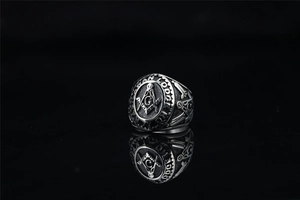 Macro shot of Freemasonry logo engraving on vintage steel ring with black background