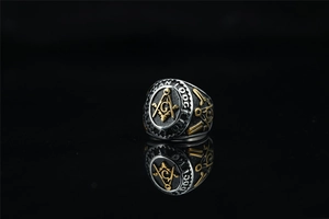 Macro shot of silver and gold Freemason ring showing G symbol and Lodge engraving