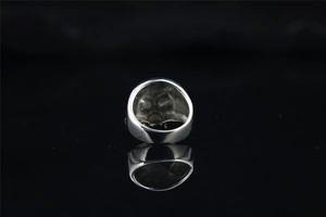 Gros plan détaillé d'une bague tête de mort en argent de style gothique punk sur noir