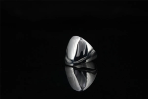 Close-up of a high-polished silver geometric ring with mirror finish and reflection