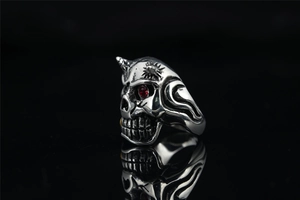 Macro shot of punk skull ring with red gemstone eyes and star engraving details