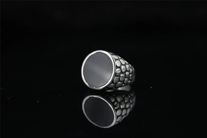 Macro detail of men's vintage ring featuring relief texture and black obsidian stone inlay
