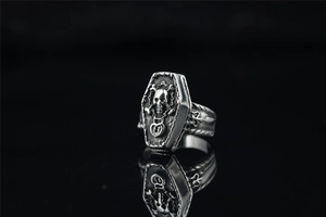 Gros plan sur la bague punk vintage avec forme de cercueil et relief de crâne 3D