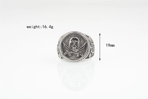 Close-up of vintage pirate skull ring with crossbones and ship wheel engravings