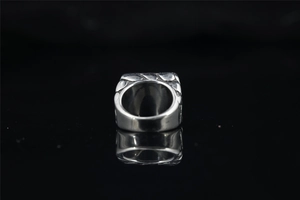 Macro shot of silver signet ring with obsidian stone and vintage relief patterns