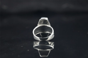 Vue arrière d'une bague en argent poli avec dessus trapézoïdal et reflet de miroir