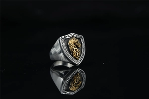 Close-up of vintage shield-shaped signet ring with gold horse head relief and silver finish