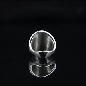 Polished silver punk style square signet ring for men on a black reflective surface