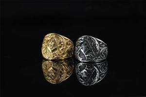 Macro shot of gold and silver Masonic rings with square and compass symbols